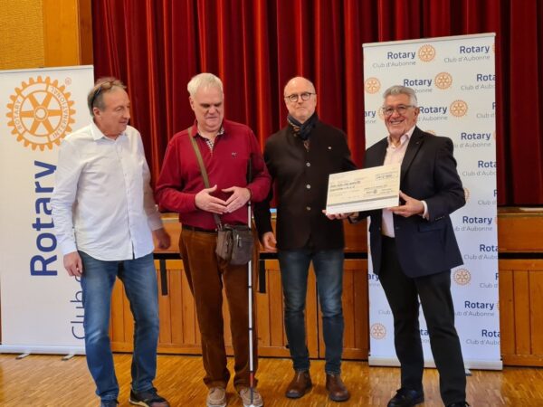 Ces cinq personnes sont debouts avec, derrière elles, les banderoles du Rotary Club d'Aubonne.